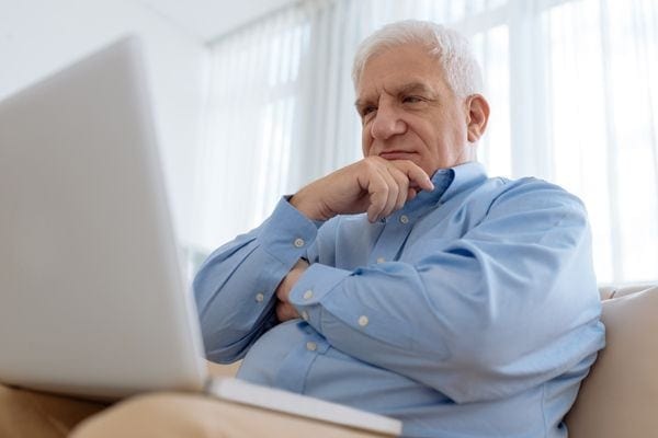 A man ponders on a laptop. How Do I Know I Have a Cracked Heat Exchanger?